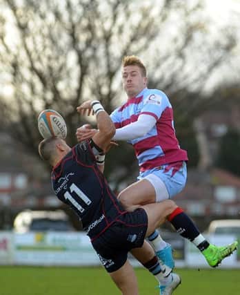 Titans' Yiannis Loizias is challenged in the air against Scottish. Picture Scott Merrylees
