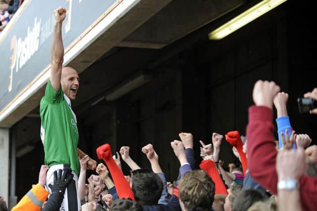 Jones celebrates among Rovers supporters after winning promotion at Brentford in 2013