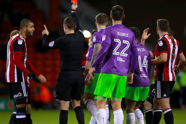 Referee David Coote shows the red card to John Fleck as Leon Clarke protests