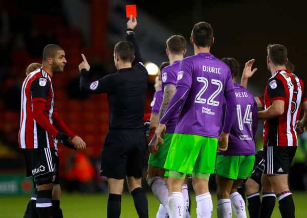 Referee David Coote shows a red card to John Fleck as Leon Clarke protests