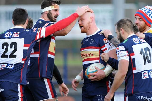 Jason Hill is congratulated on scoring one of Knights' tries. Picture Scott Merrylees