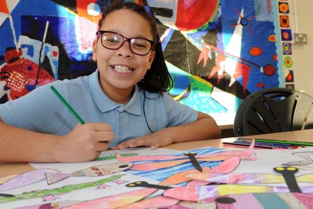 Year 6 pupil Amia, of Malin Bridge Primary School contributes to the artboat collage.