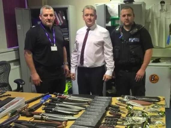 Sergeant Stuart Rowse, DCI Paul Wilson and PC Sam Robinson pose with some of the weapons which were uncovered during the search (SYP)