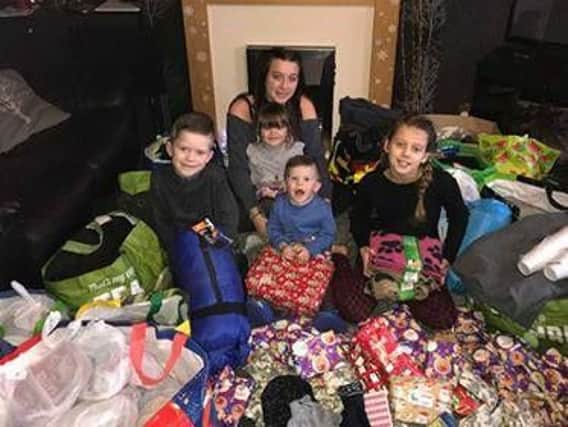 The Woodliff children with some of the presents due to be handed out. Holly is on the far right, Isabelle is at the back with Sapphire on her lap, Lewis is on the left and Ruben is in the middle at the front