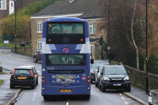A bus travels between two cars.