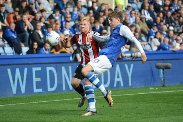 Adam Reach of Sheffield Wednesday attempts to clear the ball away from Mark Duffy