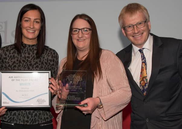 Yorkshire Air Ambulance Director of Marketing and Communications Abby Barmby (centre) and Marketing and Communications Manager Olivia Johnson receive the Air Ambulance Service Award at the Health Business Awards from Dr Phil Hammond.