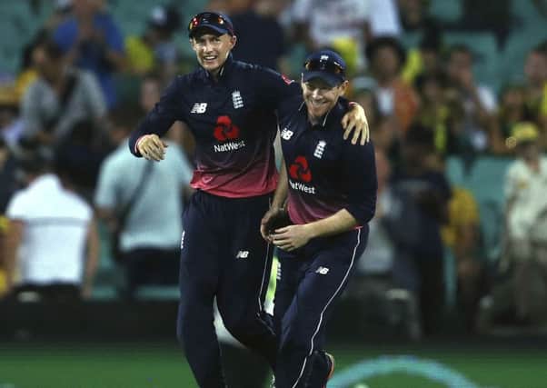 England's captain Eoin Morgan, right, celebrates with Joe Root after their win over Australia in their one day international cricket match in Sydney, Sunday, Jan. 21, 2018. (AP Photo/Rick Rycroft)