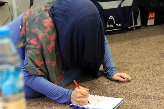 The woman writes on a pad.