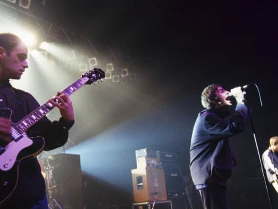 Paul Arthurs performing on stage with Oasis.