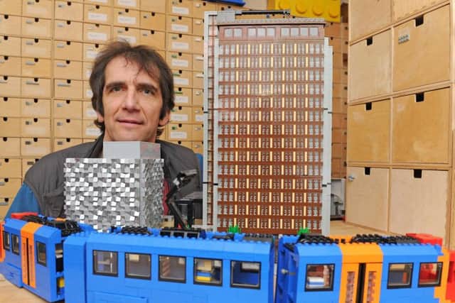 LEGO mad Michael LeCount with the 'Cheesgrater' car park and St Paul's Tower. His son also constructed the iconic Supertram. Michael, who is one of the leading builders and collectors, bought a second home to store his huge haul. LEGO is 60 on Sunday. Picture: Andy Roe/The Star