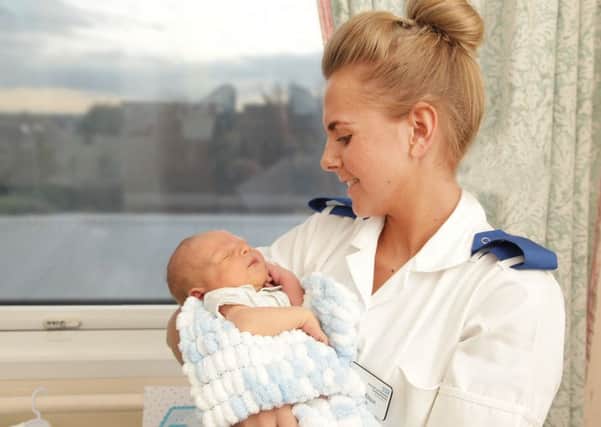 A midwife holds a newborn baby