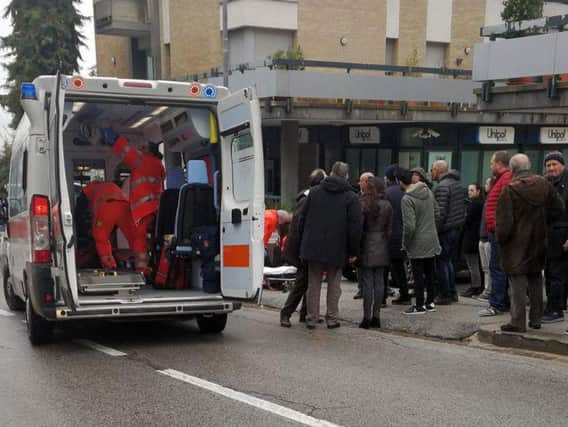 Paramedics attend a wounded man after a shooting broke out in Macerata, Italy. (Guido Picchio/ANSA via AP)