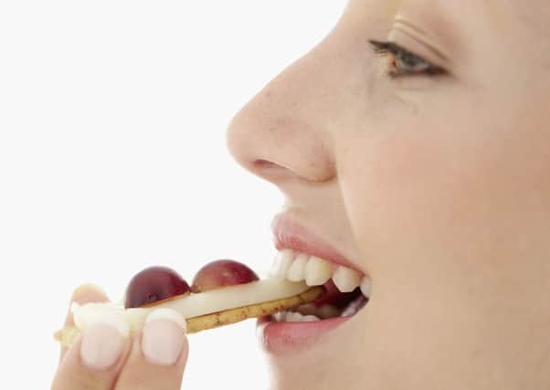 A Generic Photo of the side profile of a woman biting into cheese on a cracker, with grapes. See PA Feature TOPICAL Surprising Slim. Picture credit should read: PA Photo/thinkstockphotos. WARNING: This picture must only be used to accompany PA Feature TOPICAL Surprising Slim.