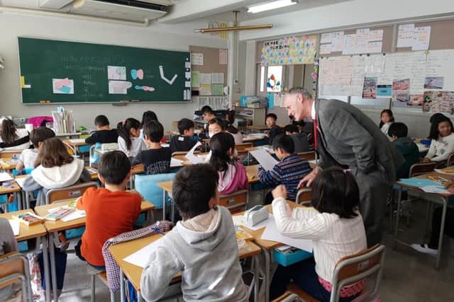 Paul Stockley speaks with children during his visit to a Japanese school
