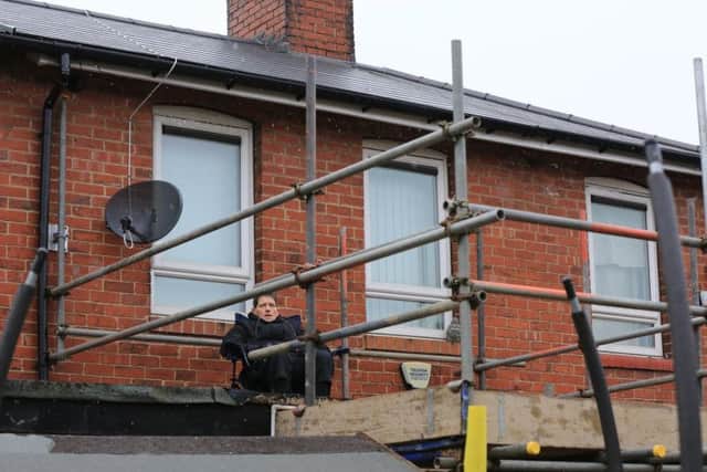 Tina Bradburn on on her neighbour's flat roof in protest at council contractors. Picture: Chris Etchells/The Star