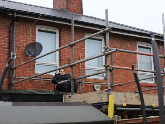 Tina Bradburn on on her neighbour's flat roof in protest at council contractors. Picture: Chris Etchells/The Star