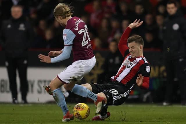 Lee Evans tackles Aston Villa's Birkir Bjarnason
