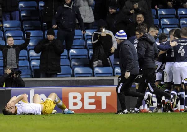 Owls Jordan Thornily lays out injured as Millwall celebrate their winner.....Pic Steve Ellis