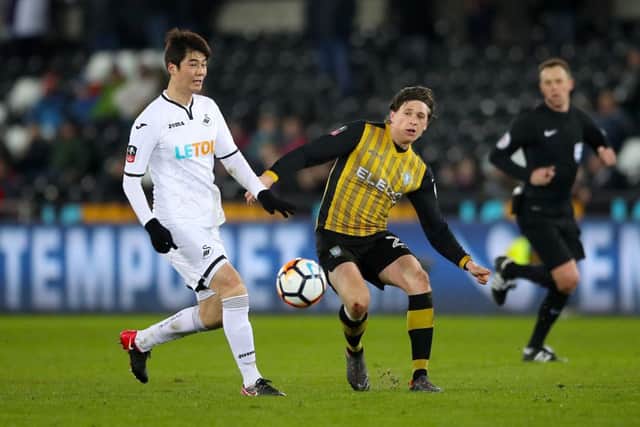 Swansea City's Ki Sung-yueng (left) and Sheffield Wednesday's Adam Reach battle for the ball during the Emirates FA Cup, fifth round replay match at the Liberty Stadium, Swansea. PRESS ASSOCIATION Photo.