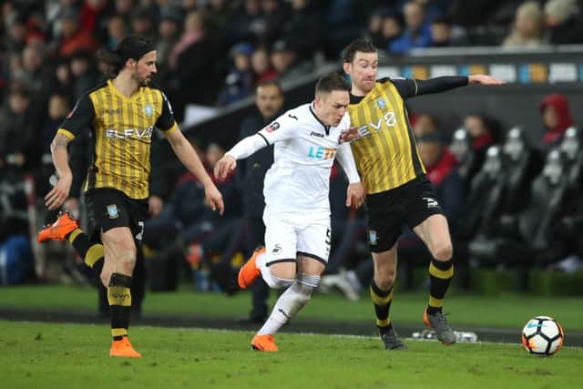 Sheffield Wednesday's George Boyd (left) Swansea City's Connor Roberts (centre) and Sheffield Wednesday's David Jones battle for the ball during the Emirates FA Cup, fifth round replay match at the Liberty Stadium, Swansea. PRESS ASSOCIATION Photo.
