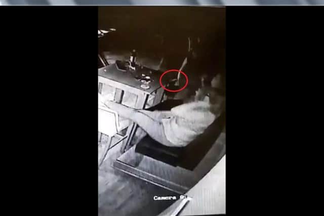 The glass (circled) flies off a table at the pub.