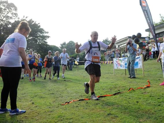 Ray Matthews finishes his 75th marathon in as many days in the grounds of Newman School.