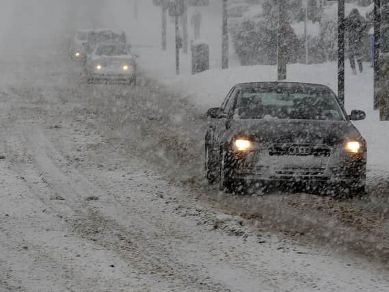 Cars travel slowly in the snowy conditions on Ridgeway Road, Manor during snow. Picture: Andrew Roe