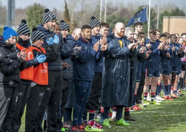Players and staff take part in a minute's applause in memory of Ian Williams who died in training last month.