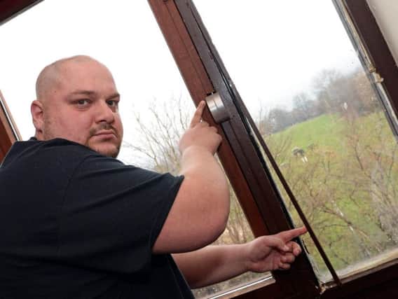 Tony Hill with one of the faulty door frames in his property. He's been asking Sheffield Council to replace them for the past 18 months. His partner's children often go to bed with extra layers and blankets because it's so cold. The local authority has since apologised and said they are now treating the planned work as priority. Picture: Marie Caley/The Star