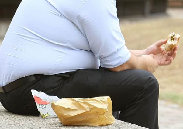 File photo dated 28/07/10 of an overweight man eating fast food as almost two out of three severely obese children under the age of 12 have at least one risk factor for heart disease such as high blood pressure or high blood sugar, researchers have said. PRESS ASSOCIATION Photo. Issue date: Tuesday July 24, 2012. The study, published online in Archives Of Disease In Childhood, examined 255 severely obese children aged between two and 18. See PA story HEALTH Obesity. Photo credit should read: Dominic Lipinski/PA Wire