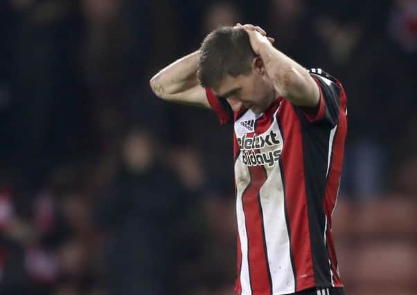 Chris Basham cuts a dejected figure after the Blades are pegged back with a late equaliser against Cardiff