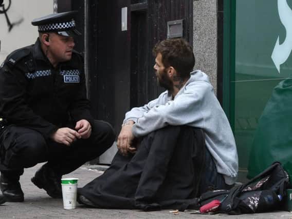 Neighbourhood PC Paul Briggs talks to a homeless person.
