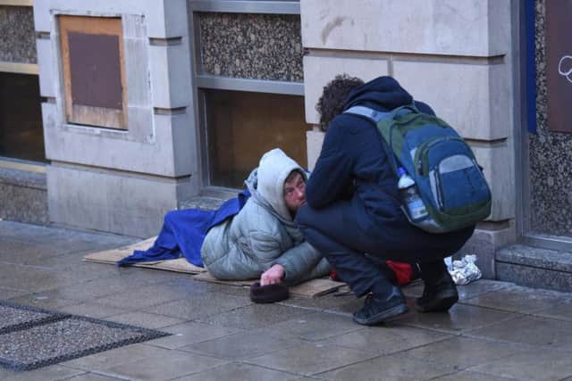 Sam Lloyd speaks to a homeless man in Sheffield.
