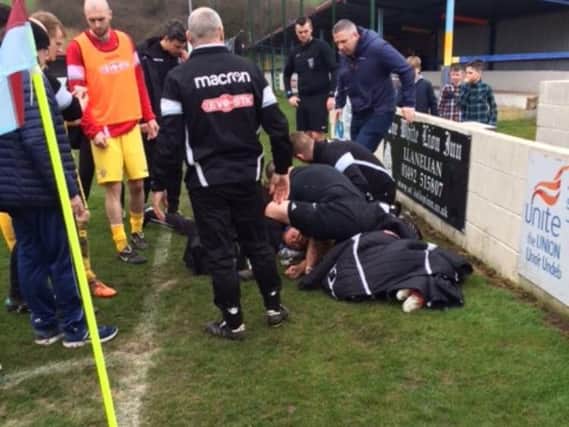 Danny receiving treatment from linesman Zharir Mustafa after his injury.