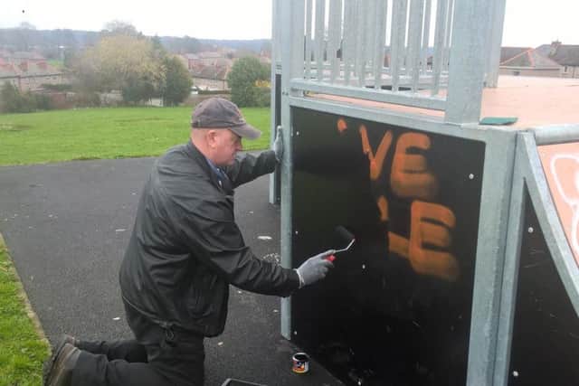 Councillor John Booker clearing graffiti