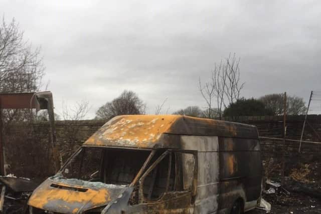 A burned out van at the centre.