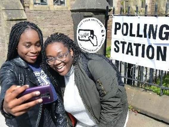 Two voters take a selfie outside a polling station