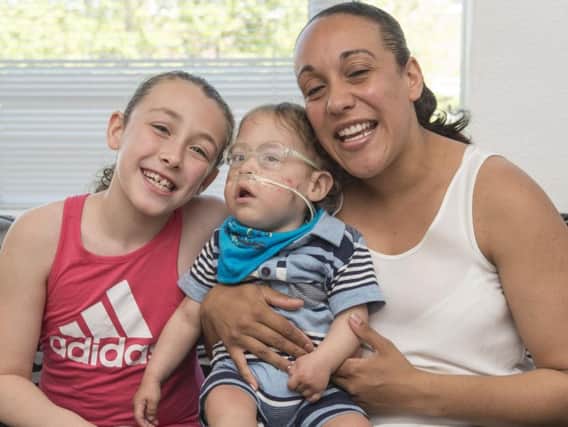 Kellen Buckler with his mum Ganelle Griffiths and sister Alicia Buckler at home in Woodseats. The family are trying to raise money for a specialist wheelchair. Picture: Dean Atkins.