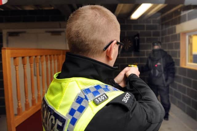 An officer takes aim with a Taser during training