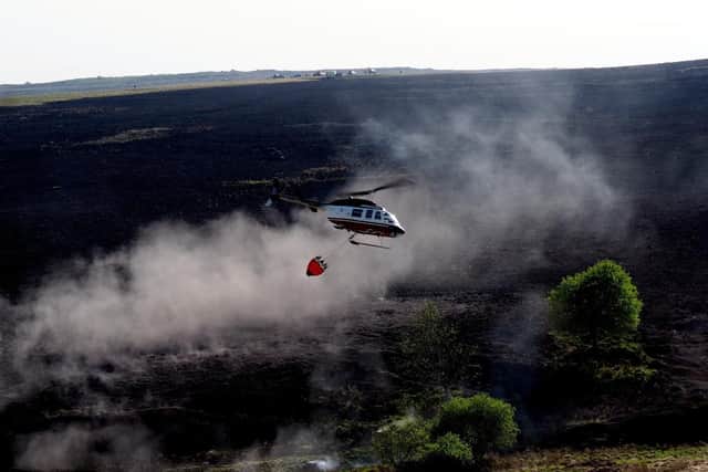 Helicopter dropping water to damp down the fire. Picture: David Bocking.