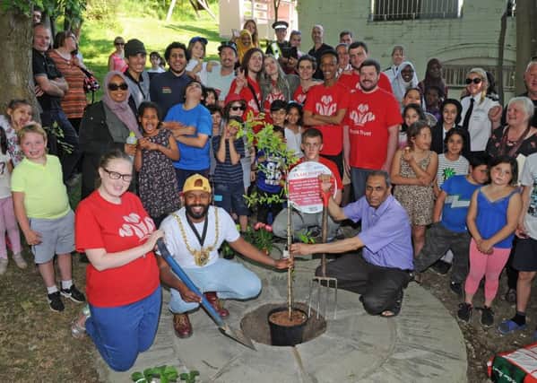 Lord Mayor Coun Magid Magid plants a tree with Coun Talib Hussian and Bailey Mansell, of the Prince's Trust at Pitsmoor Adventure Playground.