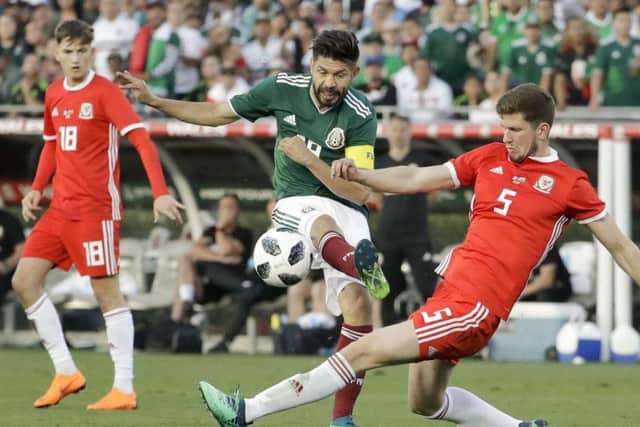 Wales' Chris Mepham, right, tackles Mexico's Oribe Peralta as David Brooks watches on